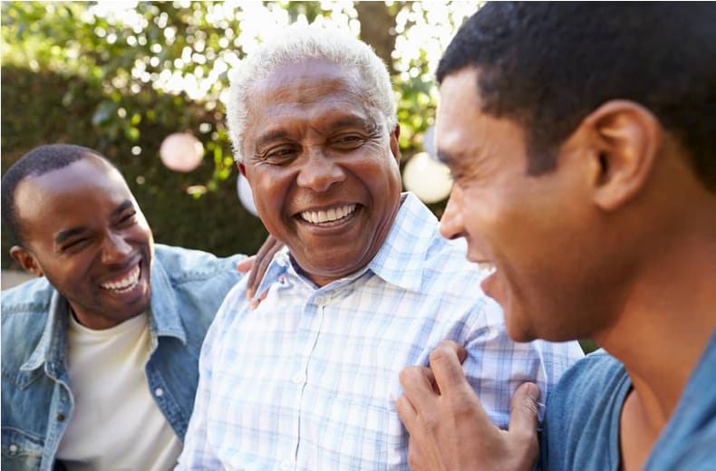 Family laughing together with an older father outdoors