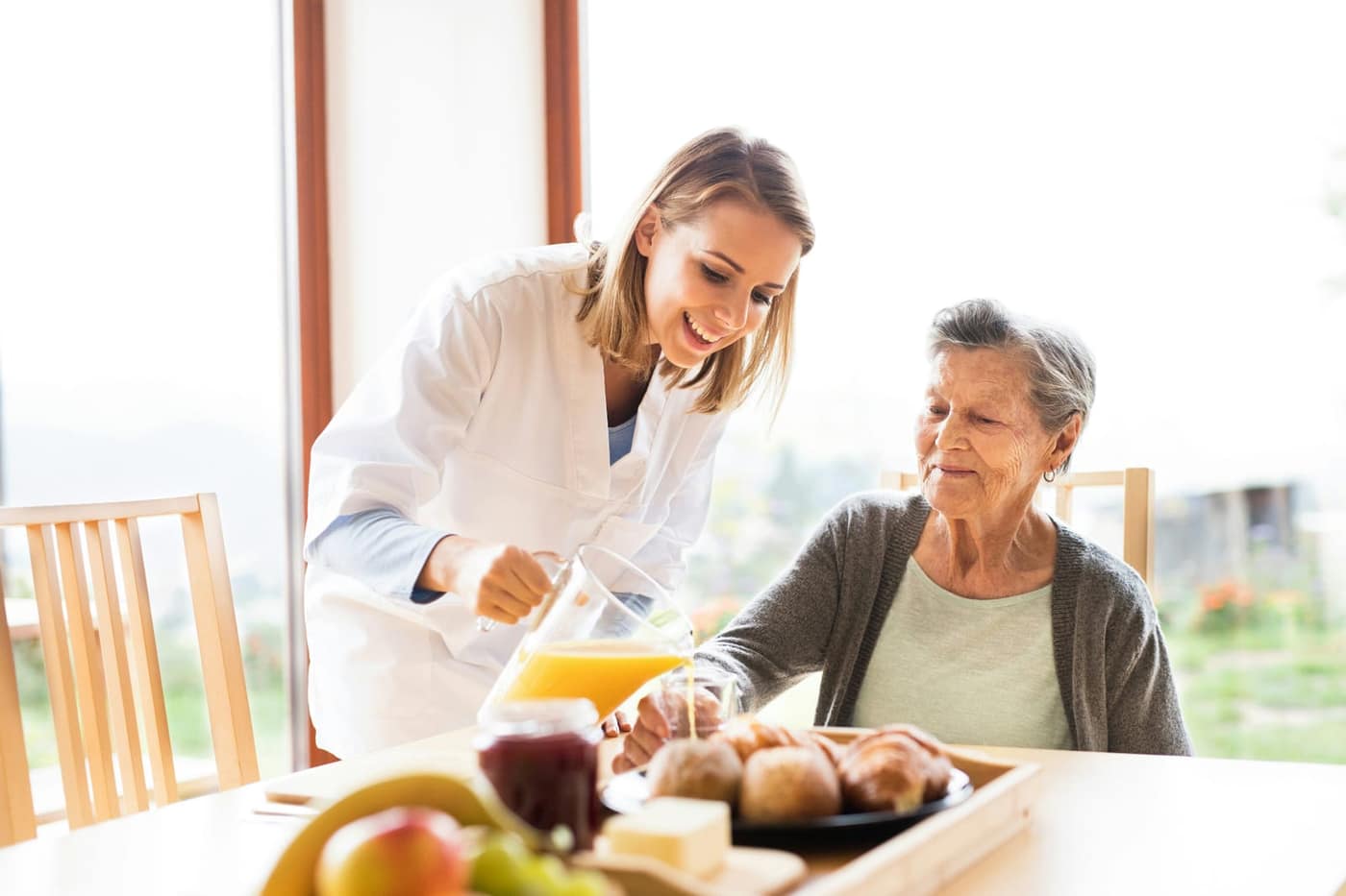 Adult daughter touring a care facility and observing staff interaction with residents